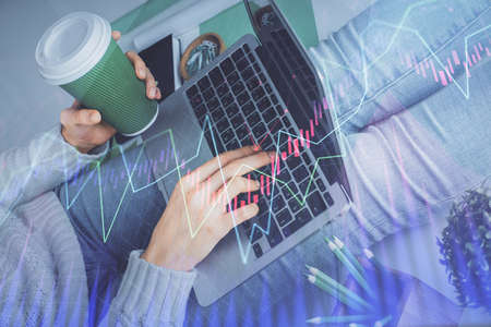 Double exposure of woman hands typing on computer and forex chart hologram drawing. Stock market...