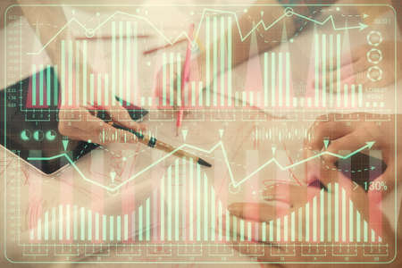 Double exposure of forex graph drawing and man and woman working together holding and using a mobile...