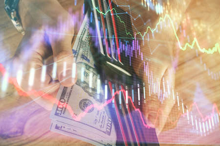 Multi exposure of forex graph drawing hologram and USA dollars bills and man hands. Technical...