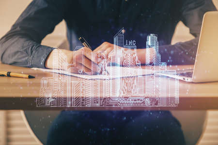 Abstract holographic city on mans hand writing notes background. Multi exposure.の写真素材