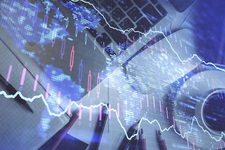Double exposure of financial chart drawing over table background with computer. Concept of research...
