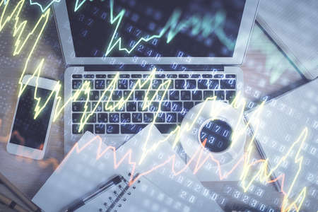 Stock market chart and top view computer on the table background. Double exposure. Concept of...