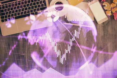 Financial market graph and top view computer on the desktop background. Double exposure. Investment...
