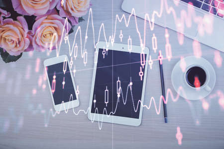 Double exposure of forex graph hologram over desktop with phone. Top view. Mobile trade platform concept.の写真素材