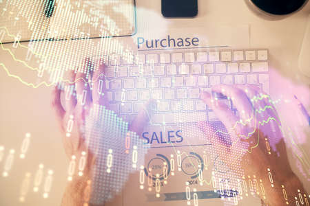 Double exposure of mans hands typing over laptop keyboard and forex chart hologram drawing. Top...