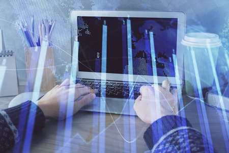 Double exposure of woman hands typing on computer and forex chart hologram drawing. Stock market...