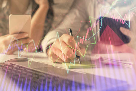 Double exposure of man and woman working together and financial graph hologram. Business concept....