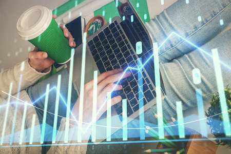 Double exposure of woman hands typing on computer and forex chart hologram drawing. Stock market...