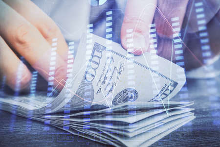 Multi exposure of forex graph drawing hologram and USA dollars bills and man hands. Technical...