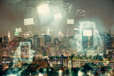 Double exposure of envelop hologram flying from gadget and city view background. Concept e-mail.の写真素材