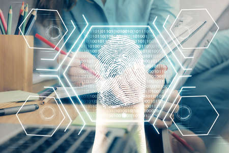 Blue fingerprint hologram over womans hands taking notes background. Concept of protection. Double...