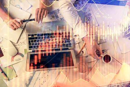 Double exposure of man and woman working together and financial graph hologram. Business concept....