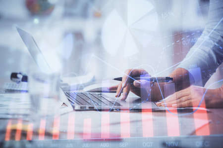 Double exposure of woman hands typing on computer and forex chart hologram drawing. Stock market...