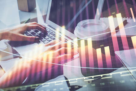 Double exposure of woman hands typing on computer and forex chart hologram drawing. Stock market...