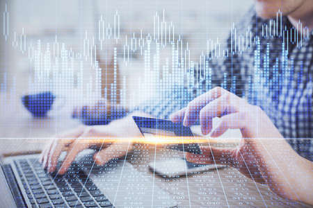 Double exposure of man hands holding a credit card and Forex graph drawing. Stock trading and...