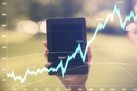 Double exposure of forex chart sketch hologram and woman holding and using a mobile device. Financial market concept.の写真素材