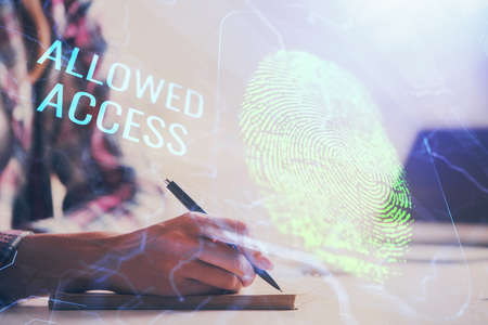 Blue fingerprint hologram over womans hands taking notes background. Concept of protection. Double...