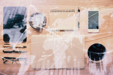 Double exposure of forex graph hologram over desktop with phone. Top view. Mobile trade platform...
