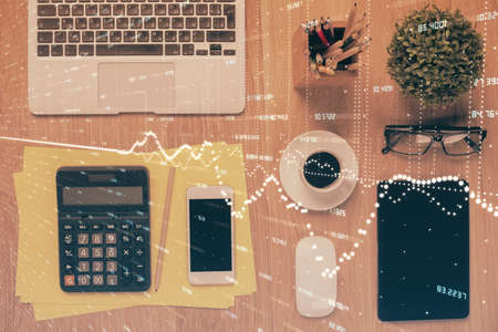 Double exposure of forex chart hologram over desktop with phone. Top view. Mobile trade platform concept.の写真素材
