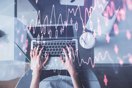 Double exposure of woman hands working on computer and forex chart hologram drawing. Top View....