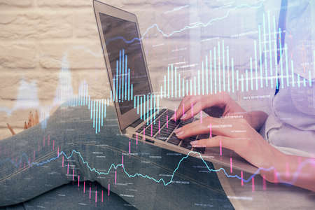 Multi exposure of woman hands typing on computer and forex chart hologram drawing. Stock market...