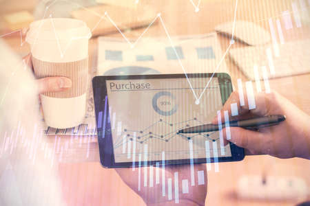 Double exposure of mans hands holding and using a phone and financial chart drawing. Market analysis concept.の写真素材
