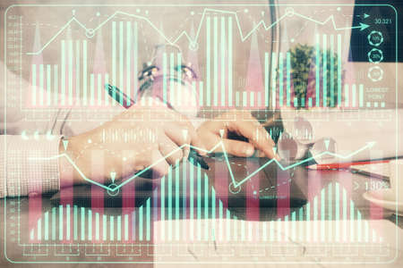 Double exposure of mans hands holding and using a phone and financial graph drawing. Analysis...