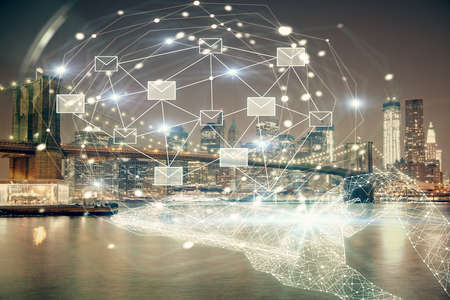 Double exposure of envelop hologram flying from gadget and city view background. Concept e-mail.