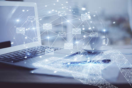 Desktop computer background in office and flying envelops hologram drawing. Double exposure....