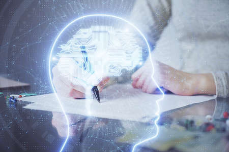 Double exposure of womans writing hand on background with brain hud. Concept of learning.