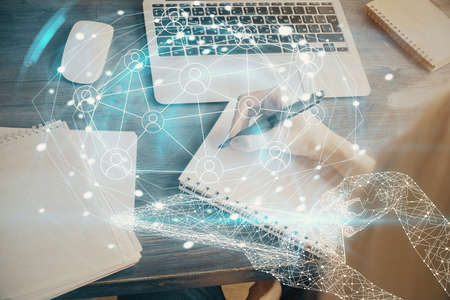 Social network theme hologram over womans hands writing background. Concept of international people...