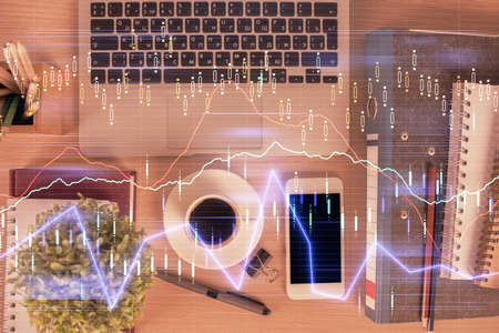 Double exposure of financial graph hologram over desktop with phone. Top view. Mobile trade platform...