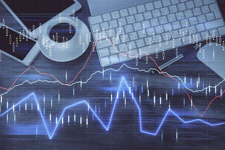 Double exposure of forex chart hologram over desktop with phone. Top view. Mobile trade platform...