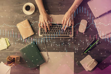 Multi exposure of woman hands working on computer and forex chart hologram drawing. Top View....