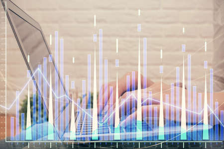 Multi exposure of woman hands typing on computer and forex chart hologram drawing. Stock market...
