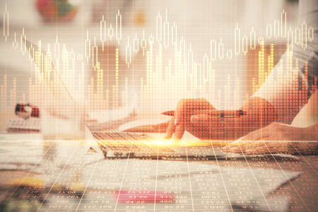 Double exposure of woman hands typing on computer and forex chart hologram drawing. Stock market invest concept.の写真素材