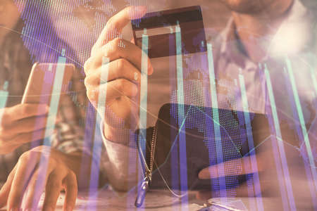 Double exposure of man and woman on-line shopping holding a credit card and forex graph hologram...