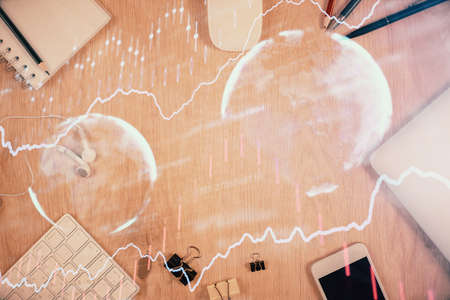 Multi exposure of forex graph hologram over desktop with phone. Top view. Mobile trade platform...