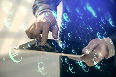 Double exposure of mans hands holding and using a digital device and forex graph drawing. Financial...