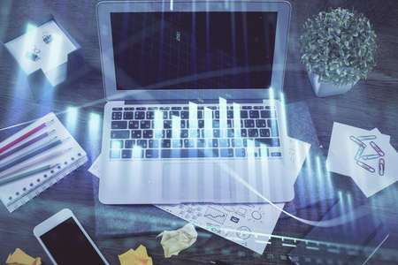 Financial chart drawing and table with computer on background. Double exposure. Concept of...