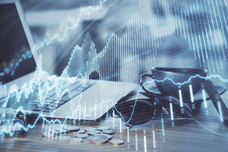 Financial chart drawing and table with computer on background. Double exposure. Concept of...