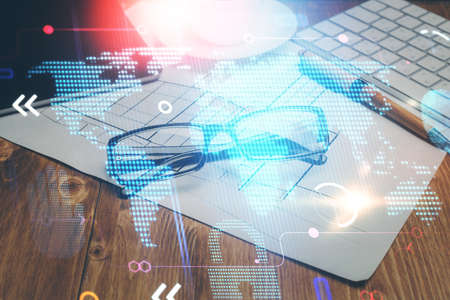 Map hologram with glasses on the table background. Concept of globalization. Double exposure.
