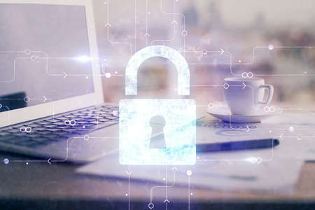 Double exposure of desktop with computer and lock icon hologram. Concept of data safety.