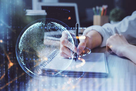 Double exposure of hands making notes with world map hologram and data theme icons. Concept of global computer data.の写真素材