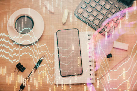 Multi exposure of forex graph hologram over desktop with phone. Top view. Mobile trade platform...