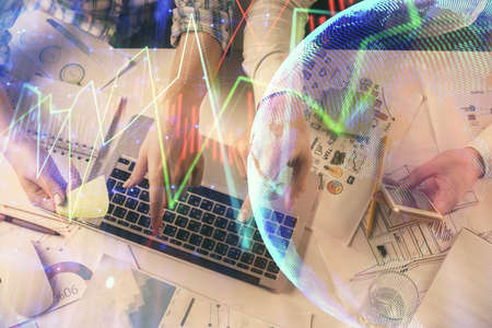 Multi exposure of man and woman working together and forex graph hologram drawing. Financial...