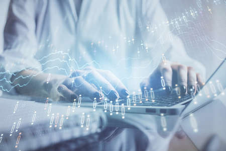 Double exposure of woman hands typing on computer and forex chart hologram drawing. Stock market...