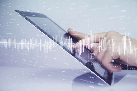 Multi exposure of mans hands holding and using a digital phone and forex graph drawing. Financial...