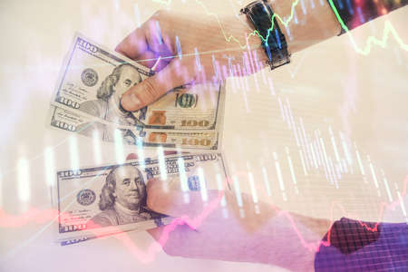 Multi exposure of financial graph drawing hologram and USA dollars bills and man hands. Analysis...