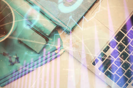 Double exposure of forex graph drawing over desktop background with computer. Concept of financial...